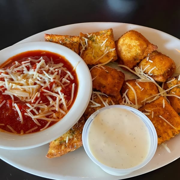 Fried ravioli and cheese bites with marinara sauce and a side of ranch dressing.