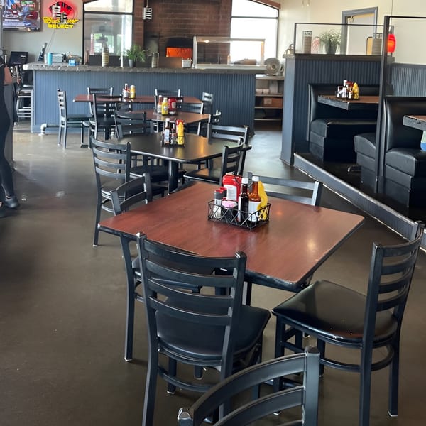 Interior of Reifschneiders Grill and Grape, showing dining tables, chairs, booths, and a bar area.