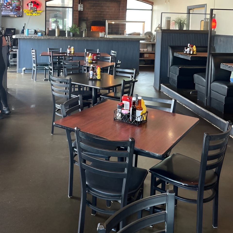 Interior of Reifschneiders Grill and Grape, showing dining tables, chairs, booths, and a bar area.